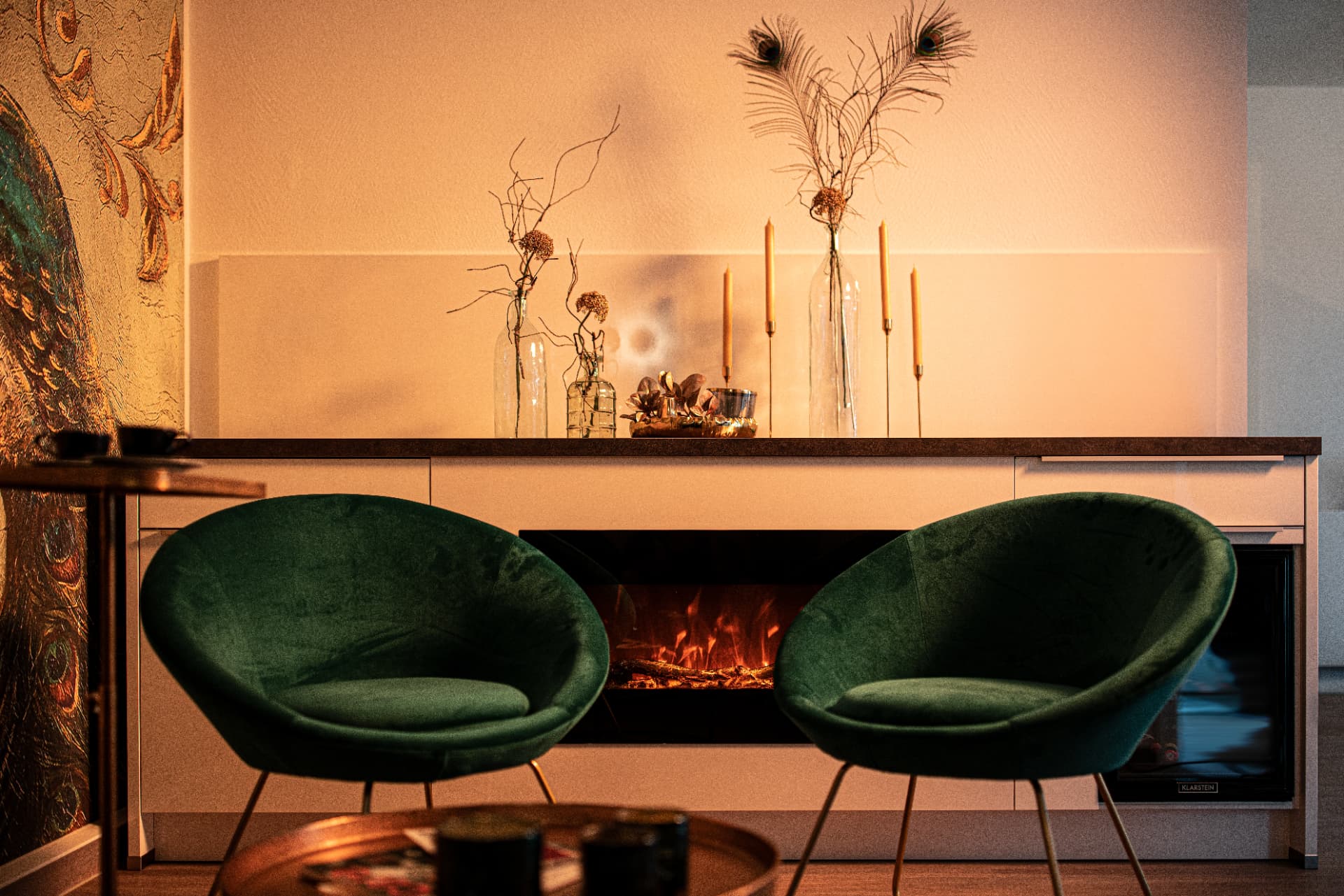 Gemütliche Wartelounge mit grünen Sesseln und Kamin im Institut